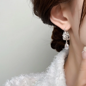 Detailed view of silver butterfly earring with sparkling zircon and pear drop gemstone