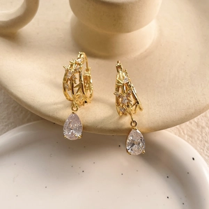 Elegant gold branch drop earrings with tiny diamonds and pear-shaped clear crystals