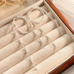 Detailed view of silver tassel earrings with glittering rhinestones on beige velvet