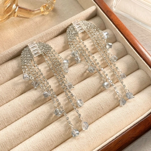 Detail of silver tassel earrings with zircon butterflies and blue crystal accents