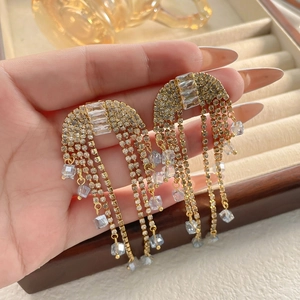 Detailed close-up of bridal tassel earrings with zircons and blue crystal beads