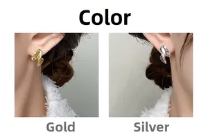 Detail view of gold and silver irregular wavy stud earrings in minimalist style