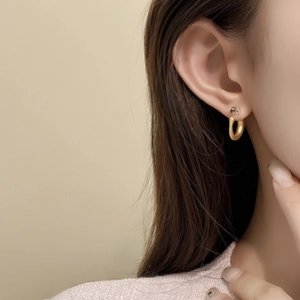 Minimalist 18K gold plated snake-style hoop earrings worn by a model for a chic look