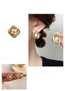 Détails macro de boucles d'oreilles géométriques dorées avec perle et cristaux