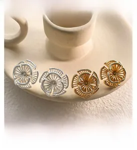 Détail de boucles d'oreilles tournesol en or et argent avec texture évidée en fil enroulé