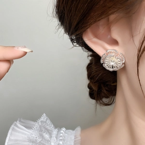 Élégantes boucles d'oreilles tournesol en laiton plaqué argent 18K portées par un mannequin