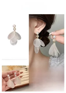 Detail of white shell petal tassel earrings with pearls and crystal accents