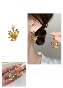 Gros plan détaillé des boucles d'oreilles fleurs dorées avec pétales en cristal 3D