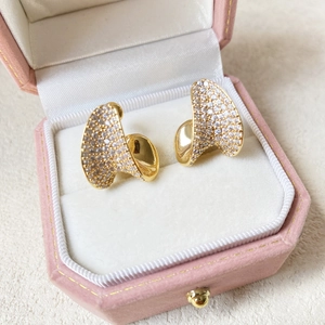 Close-up of sparkling heart stud earrings with cubic zirconia in a pink velvet jewelry box