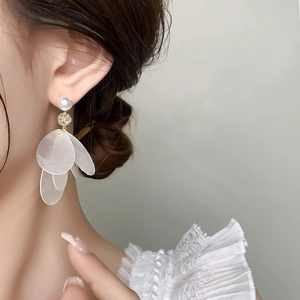 Detailed close-up of long white shell tassel earrings with pearls and crystals