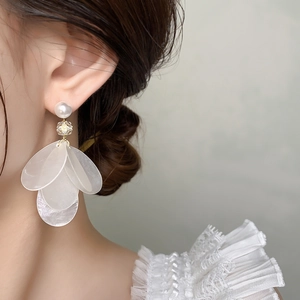 Detail of elegant white shell petal earrings with pearls on model with lace collar