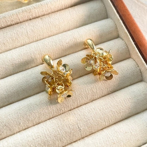 Boucles d'oreilles fleurs dorées avec zircons étincelants sur support en velours