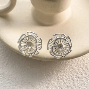 Vue détaillée de boucles d'oreilles tournesol en argent avec texture florale complexe