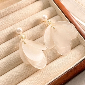 White shell petal tassel earrings with pearls and gold accents in a beige jewelry box