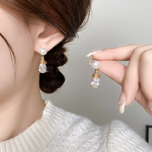 Boucles d'oreilles élégantes en perles et cristal avec fil d'or sur modèle