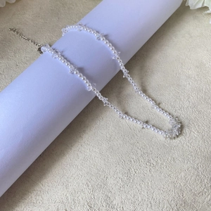 Detail of beaded pearl necklace with clear iridescent crystals and silver lobster clasp