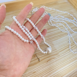Detailed shot of beaded baroque necklace with white pearls and silver textured bead