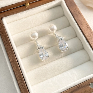 Détail macro de boucles d'oreilles cristal goutte avec perle et fil d'argent tressé