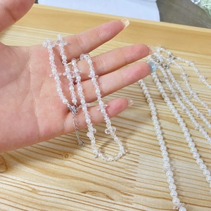 Detail of beaded necklace featuring shell pearls and cubic zirconia on a lobster clasp