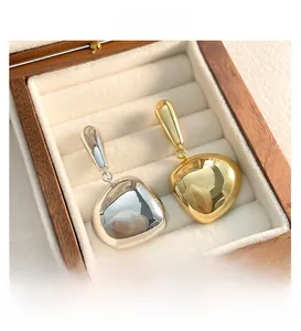 Detailed macro view of organic drop-shaped 18K gold and silver plated tassel earrings