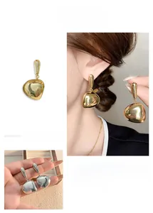 Macro detail of geometric mirror-polished gold and silver long tassel earrings for women