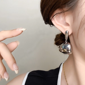 Minimalist silver-plated teardrop earrings with high-polish finish on a female model