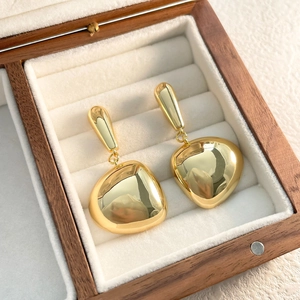 Close-up of 18K gold-plated teardrop tassel earrings displayed in a velvet jewelry box