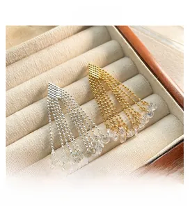 Detail of gold and silver copper tassel earrings with zircon beads in a jewelry box