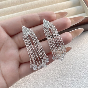 Elegant long tassel earrings with silver bead chains and clear crystal pendants in hand