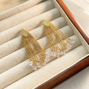 Close-up of elegant gold-plated tassel earrings with five bead chains and zircon pendants