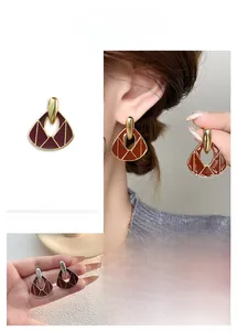 Detail of vintage asymmetrical heart fan-shaped enamel earrings with gold and silver plating