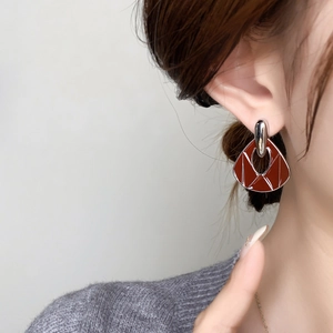 Detail of vintage terracotta geometric earring on model with silver accents