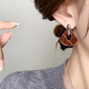 Vintage geometric fan-shaped earrings with red-brown enamel and silver metal on model