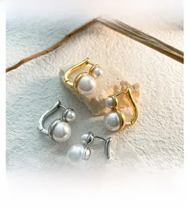 Close-up of French vintage U-shaped earrings with double pearls on gold and silver bases