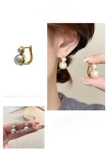 Detail of French vintage pearl drop earrings with double pearls and gold plated finish