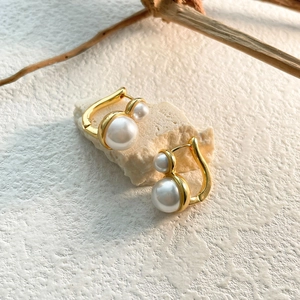 Detail of French vintage gold-plated earrings featuring double pearls on natural stone