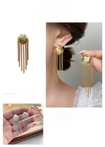 Détail macro de boucles d'oreilles sphériques de luxe avec pampilles dorées et argentées