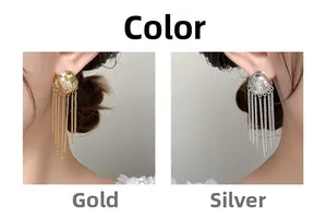 Détail de boucles d'oreilles à pompons métalliques longs en couleurs or et argent serties