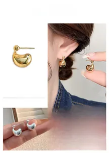 Detailed view of minimalist metal stud earrings in gold and silver irregular water drop shapes