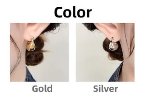 Close-up of minimalist teardrop metal earrings in gold and silver mirror finishes