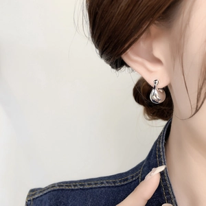 Macro view of minimalist silver streamline stud earring on model for a modern look