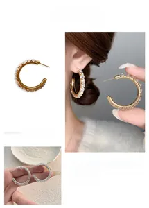 Detailed view of elegant C-shaped silver needle hoop earrings with pavé set crystals