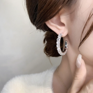 Exquisite silver hoop earrings with full micro-pave crystals shown on a female model