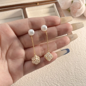 Eleganti orecchini lunghi con nappe con perle bianche e pendenti scintillanti in oro