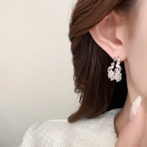 Gros plan de boucles d'oreilles argentées en C avec texture de cristal de glace pilée