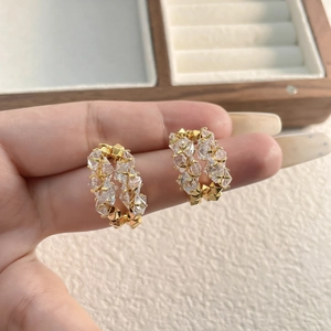 Gros plan de boucles d'oreilles dorées en C avec double rangée de zircons pour femmes