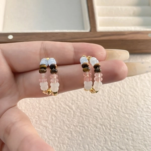 Détail de boucles d'oreilles bohèmes en forme de C avec perles colorées et dorées