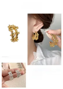 Detail of C-shaped hoop earrings with textured silver beads in gold and silver finish