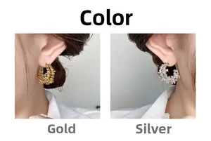 Detailed close-up of C-shaped earrings showing textured gold and silver finishes