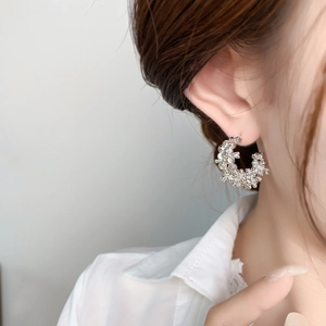 Exquisite silver floral C-shaped hoop earrings with textured finish shown on model